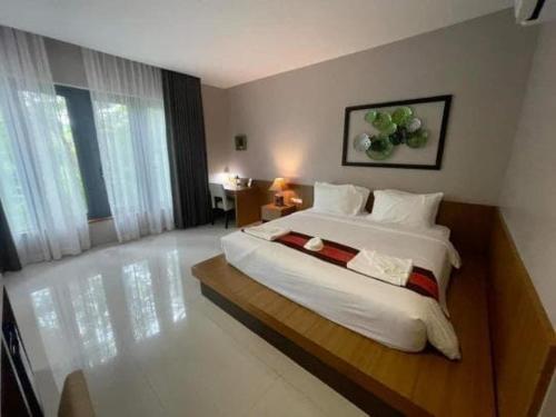 a bedroom with a large white bed in a room at Bangnu Greenery Resort in Takua Thung