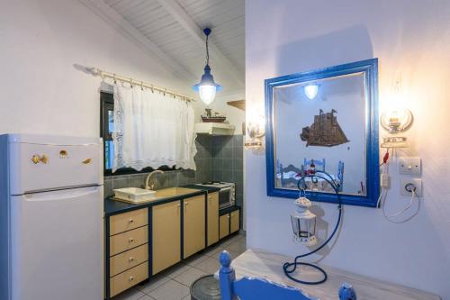 uma cozinha com um frigorífico e uma imagem na parede em The Blue House Seaside Retreat - Fully equipped em Chrani