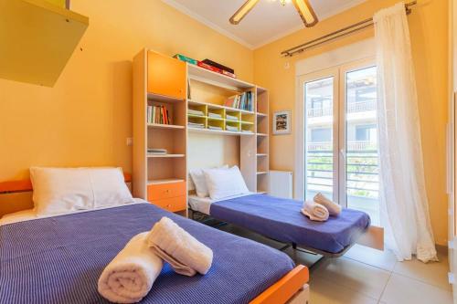 a bedroom with two beds and a book shelf at Navarino Captains Villa - Lux Private Pool Retreat in Marathopolis