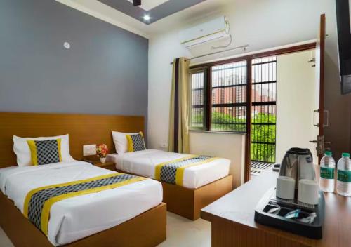 a bedroom with two beds and a television in it at Blue Castle Inn in Greater Noida