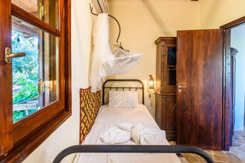 a small bedroom with a bed with towels on it at The Fairytale House Seaside Retreat in Chrani