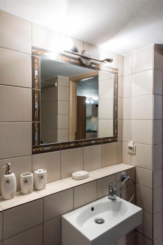 a bathroom with a sink and a mirror at Porto Cheli Studio - Poolside Lux Getaway in Porto Heli