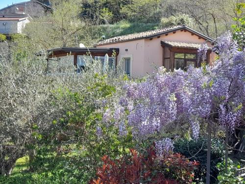 een huis midden in een tuin met paarse bloemen bij Villa Clementine in Piazza Armerina