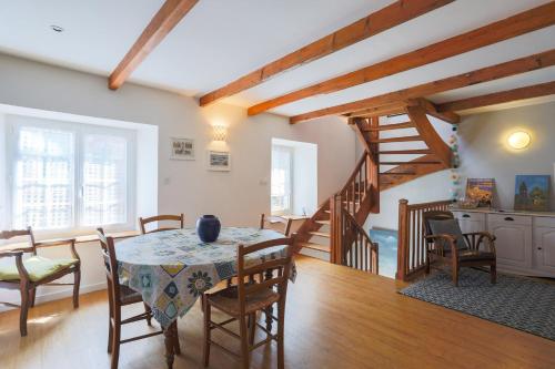 une salle à manger avec une table et des chaises et un escalier dans l'établissement Gîte de Charme - 4 personnes, à Paimpol