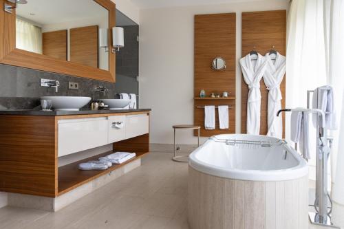 a bathroom with a tub and a sink at AlpenGold Hotel Davos in Davos