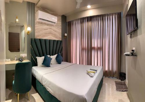 a hotel room with a large bed and a desk at Hotel Grand Nidhivan in Nagpur