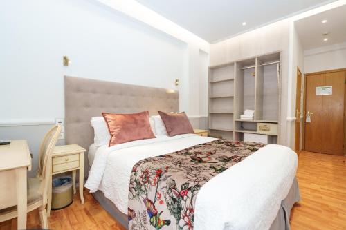 a bedroom with a large bed and a desk at Acropolis Ami Boutique Hotel in Athens