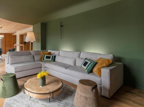 a living room with a couch and a table at L'Alcôve - Chalet avec Piscine in Xonrupt-Longemer