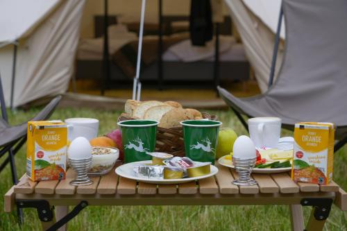 stół piknikowy z koszem żywności i jaj w obiekcie Camp Pera w mieście Täsch
