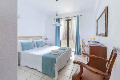 1 dormitorio con 1 cama, 1 silla y 1 ventana en A Slice of Heaven on Earth - Villa Ariadni at Sani en Sani Beach
