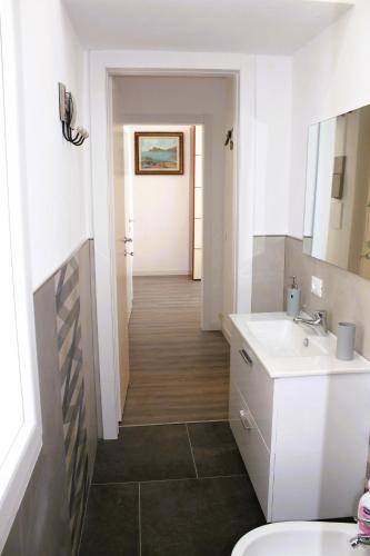 a bathroom with a sink and a toilet and a hallway at Rachele Guest House La Spezia in La Spezia