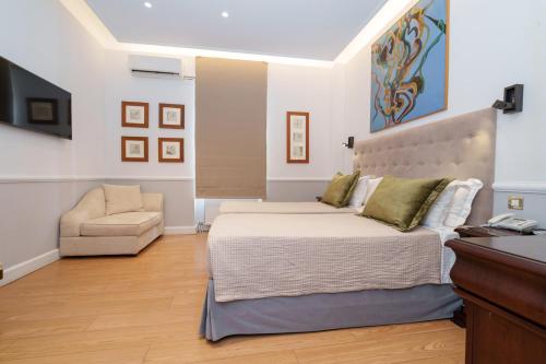 a bedroom with a large bed and a chair at Acropolis Ami Boutique Hotel in Athens