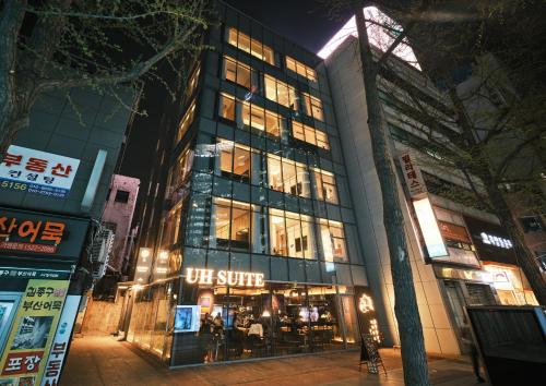 a building with a u store on a city street at night at UH Suite Seoul Deoksugung in Seoul