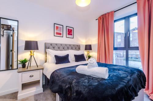 a bedroom with a large bed with a towel on it at Beautiful Manchester Home Sleeps 9 by PureStay Short Lets in Manchester