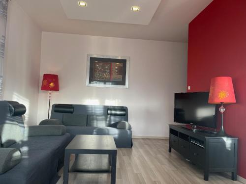 a living room with a couch and a flat screen tv at Apartament z ogródkiem in Rewal