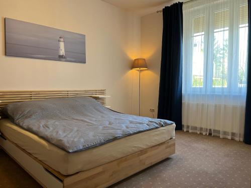 a bedroom with a bed with a lighthouse on the wall at Apartament z ogródkiem in Rewal