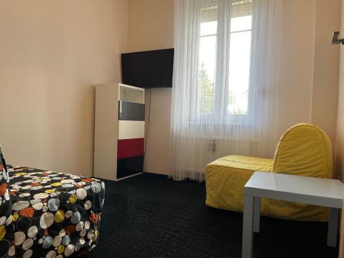 a room with a bed and a chair and a window at Apartament z ogródkiem in Rewal