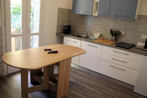 a kitchen with a wooden table and a sink at Rachele Guest House La Spezia in La Spezia
