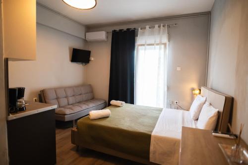 een hotelkamer met een bed en een bank bij Paralion Town Apartments in Alexandroupoli