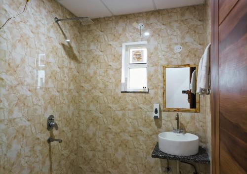 a bathroom with a sink and a mirror at Blue Castle Inn in Greater Noida