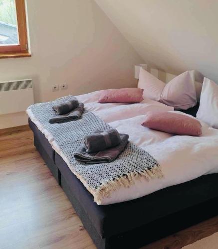 two beds with towels and pillows on top of them at Country House Liptov in Svätý Kríž