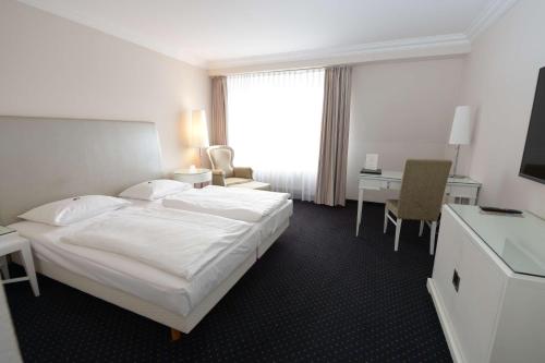 a hotel room with a bed and a desk at Hotel & Restaurant Schönau in Peine