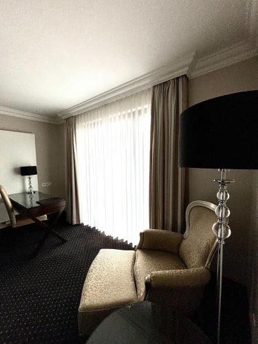 a hotel room with a chair and a window at Hotel & Restaurant Schönau in Peine