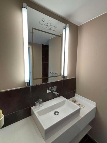 a bathroom with a white sink and a mirror at Hotel & Restaurant Schönau in Peine