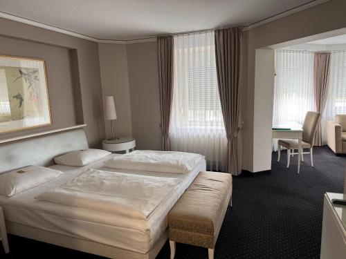 a hotel room with two beds and a desk at Hotel & Restaurant Schönau in Peine