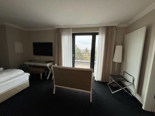 a hotel room with a bed and a desk and a window at Hotel & Restaurant Schönau in Peine