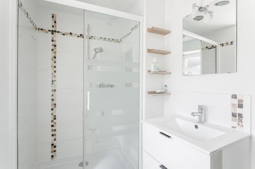 biała łazienka z prysznicem i umywalką w obiekcie Apart Sud Vendée,zen et confort w mieście Saint-Hilaire-des-Loges