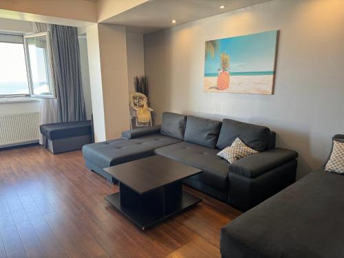 a living room with a couch and a table at Apartament Summerland Mamaia in Mamaia