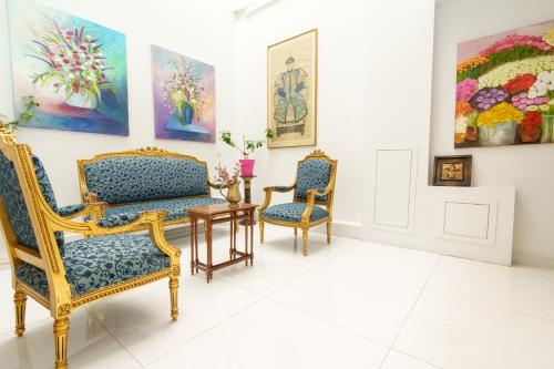 a room with two chairs and a table and paintings at Acropolis Ami Boutique Hotel in Athens