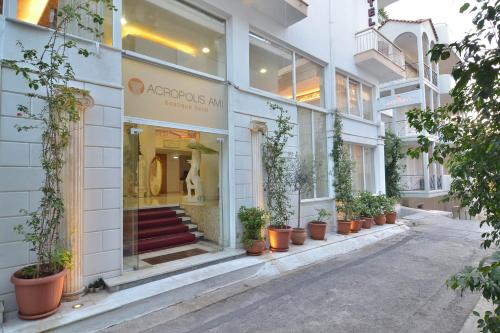 een winkel voor een gebouw met potplanten bij Acropolis Ami Boutique Hotel in Athene