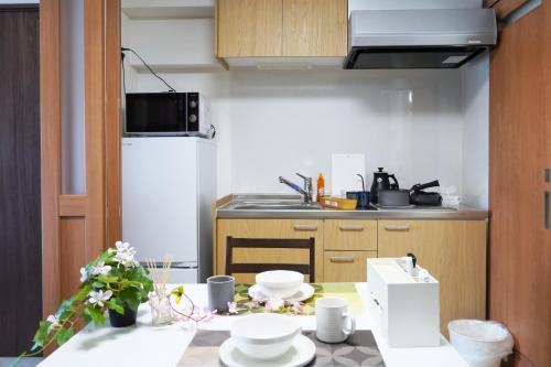 a small kitchen with a table with dishes on it at The Peak Chiyozaki in Osaka