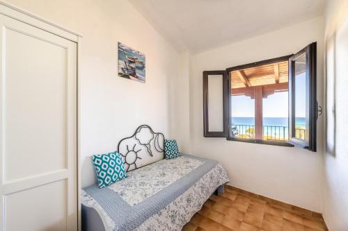 Habitación con cama, ventana y océano en Casa Mariano, en Costa Rei