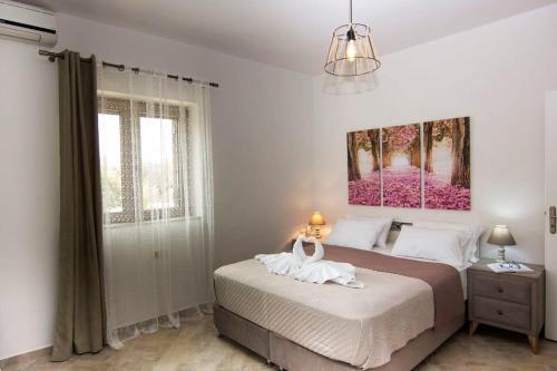a bedroom with a bed and a painting on the wall at Selinitsa Stone Home - Mani's Private Pool Retreat in Agios Nikolaos