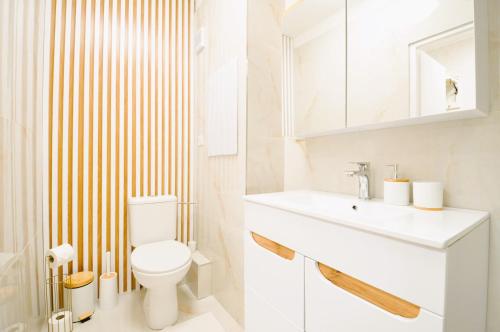 a bathroom with a white toilet and a sink at Apartment Fragrantly in Poprad