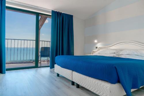 Schlafzimmer mit einem Bett und Meerblick in der Unterkunft AHG Riva Del Sole Hotel in Moniga