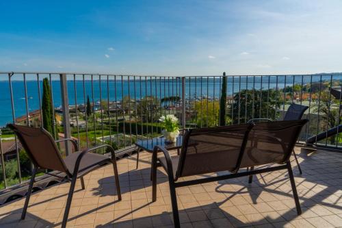 a balcony with two chairs and a view of the ocean at AHG Riva Del Sole Hotel - Adults Only in Moniga