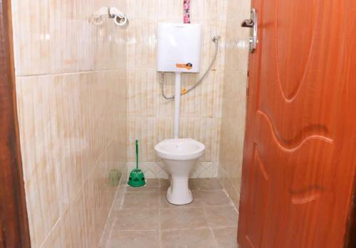 a bathroom with a toilet in a tiled room at Lulu Stays 1 Bedroom in Nyahururu