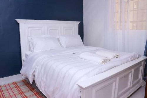 a white bed with white sheets and pillows on it at Lulu Stays 1 Bedroom in Nyahururu