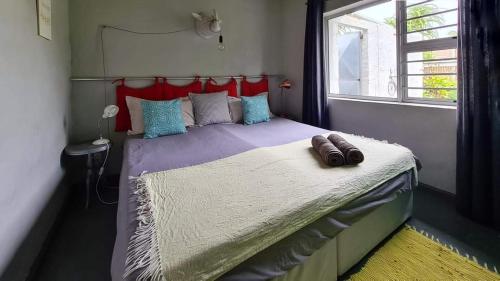 a small bedroom with a bed with a window at Under Milkwood in Chintsa