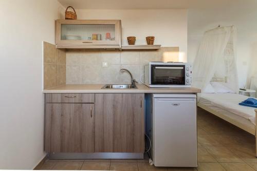 a small kitchen with a sink and a bed at Mani Panoramic Views - Private Sunny Retreat in Levktron
