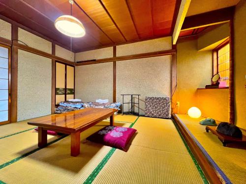 sala de estar con mesa y sofá en 松葉屋ゲストハウス, en Ō-shinden