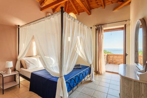 a bedroom with a canopy bed with a view of the ocean at Mani Panoramic Seaviews - Luxury Summer Haven in Lévktron