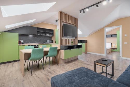 uma cozinha com armários verdes e uma mesa com cadeiras em Maniu Flats em Oradea