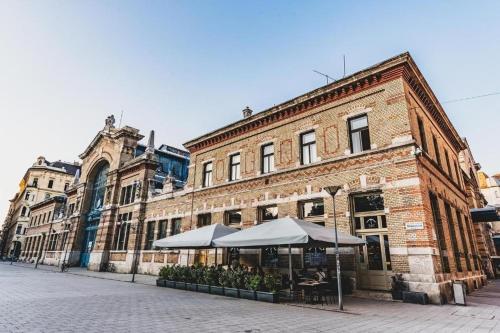 un vieux bâtiment en briques avec un parasol dans une rue dans l'établissement Dream Destination Apartment, à Budapest