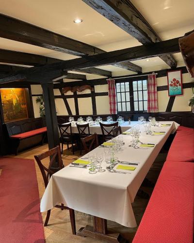 a row of tables in a room with white table cloth at Hôtel Restaurant Les Alizés in Lipsheim