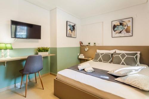 a bedroom with a bed with a chair and a television at Kalamata Lime Studio - Urban Cozy Nest in Kalamata